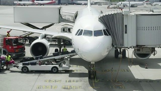 机场工作人员在飞机传送带上携带行李。工作人员将行李装上客机。慢镜头，特写视频素材模板下载