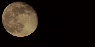 满月在黑色的背景上，可以看到表面的细节。绕月绕地