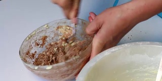 一位妇女用可可粉揉面团来准备大理石蛋糕。