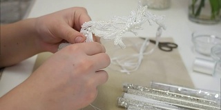 女人用手缝着白珠做发饰