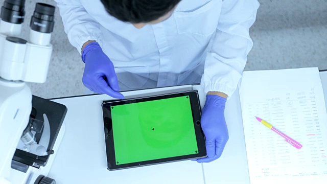 科学家在实验室使用带绿色屏幕的平板电脑