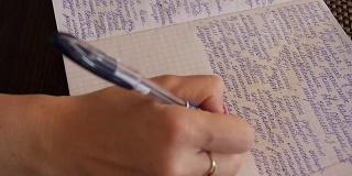 一个女人在笔记本上写手写的文字