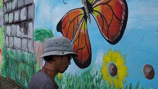 壁画画家在学校的墙上画蝴蝶。视频素材模板下载
