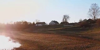 无人机拍摄:村庄上空的春天日落。在夕阳下俯瞰美丽的乡村
