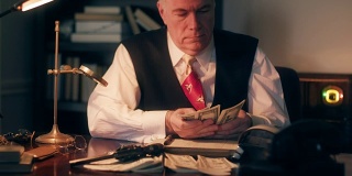 一个20世纪40年代黑帮风格的会计师在数钱，然后用钢笔在分类帐上记账。