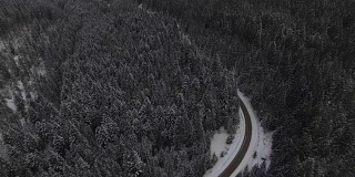 汽车行驶在雪地里的乡村道路上，无人机鸟瞰图