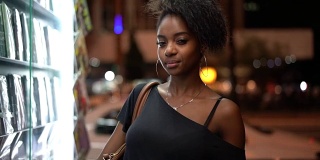年轻的黑人妇女在城市的夜晚被描绘