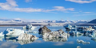 4k时间移动的云与蓝色冰山漂浮在Jokulsarlon冰湖，冰岛