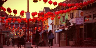 中国日落时，游客们在红灯笼下行走