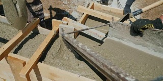 用混凝土建造小房子。液体混凝土灌注到木模板中，形成建筑物的基础