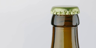 啤酒的瓶口上盖着一个金属盖。在白色的背景上