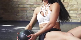 一个运动女性使用实心球做仰卧起坐的镜头的裁剪