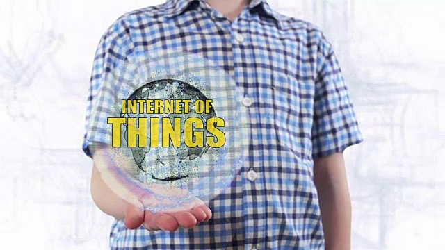 Young man shows a hologram of the planet Earth and text Internet of things