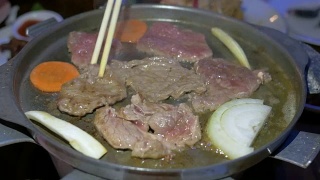 在热锅上烧烤和烤牛肉。烧烤和烤牛肉是泰国著名的街头小吃视频素材模板下载