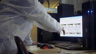 一名妇女在家禽养殖场的电脑里查看孵化器的信息视频素材模板下载