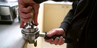 咖啡师用捣锤压碎咖啡。