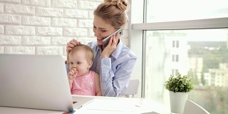 有婴儿通话电话的职业女性。商业妈妈怀上孩子