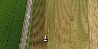空中:拖拉机在耕地上工作，骑自行车穿越乡村