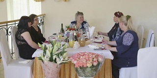 老女人和朋友们在节日晚宴上庆祝节日