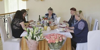 老女人和朋友们在节日晚宴上庆祝节日