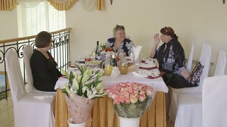 老年妇女在节日晚宴上庆祝节日。女性朋友聊天视频素材模板下载