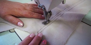中年妇女在米色织物缝纫机上手工缝制