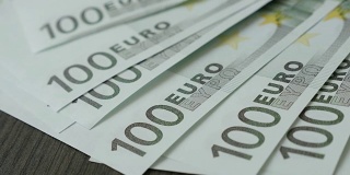 百欧元纸币跌落桌上的商业背景