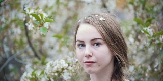 年轻女子在樱花花丛中，慢镜头
