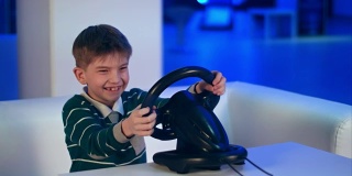 快乐兴奋的小男孩玩电子游戏与赛车轮