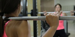女性用杠铃做硬举运动。自信的年轻女子在健身房举重锻炼