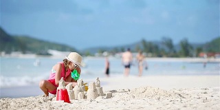 小女孩在热带海滩做沙堡