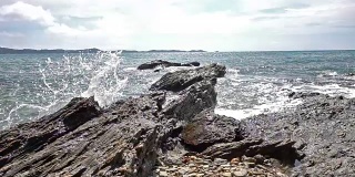 泰国热带海滩海浪击碎岩石海岸线的缓慢运动