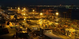 白天到夜晚延时:鸟瞰图的港口工作的货物集装箱在台场日本东京