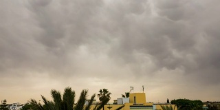 暴风雨前的乌云笼罩着屋顶。雷暴前的乌云背景。时间流逝。间隔拍摄。