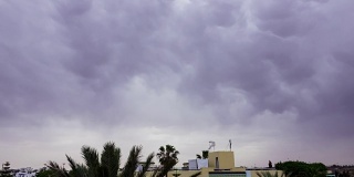 暴风雨前的乌云笼罩着屋顶。雷暴前的乌云背景。时间流逝。间隔拍摄。