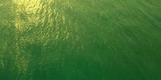 鸟瞰图海浪打破白色沙滩在日落。海浪对美丽的海滩鸟瞰图无人机全高清拍摄