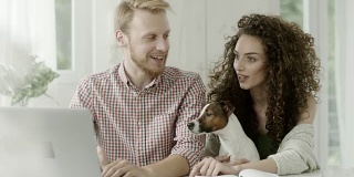 男人，女人和一只狗一起在笔记本电脑上工作