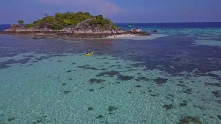 鸟瞰热带海滩，长尾船，皮划艇和岩石海岸与水晶清澈的绿松石水Koh Kla, Koh Lipe, Satun，泰国视频素材模板下载
