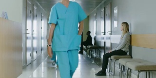 医生穿过医院走廊的照片。