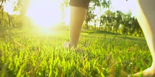 女人走过绿色的夏日草地