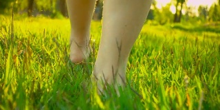 夏天的时候，女人的脚走在草地上