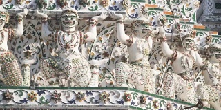 手持式低角度视角:泰国风格的雕像，作为巨大的是在Wat Arun大宝塔下