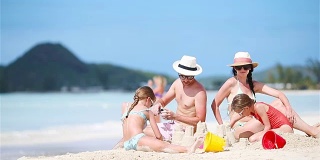 家庭制作沙堡，享受热带白色海滩度假