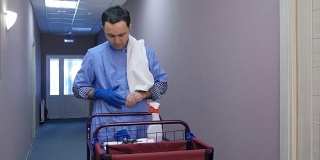 男酒店清洁工在打扫房间前戴上手套
