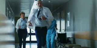 在医院的紧急情况下，医生和护士跑过走廊，急于拯救生命。