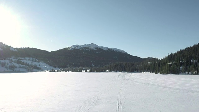 飞向一个被夕阳照亮的白雪覆盖的山峰。