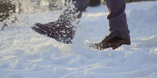 穿着靴子的男子用慢动作踢雪
