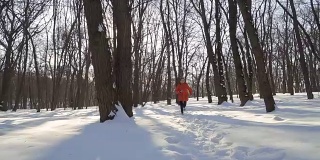 可爱的男孩在冬季公园跑步的慢镜头