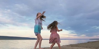 两个孩子在海滩上尽情跳舞。