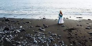 一对年轻的男女在特内里费岛浪漫风景的海滩上跳舞